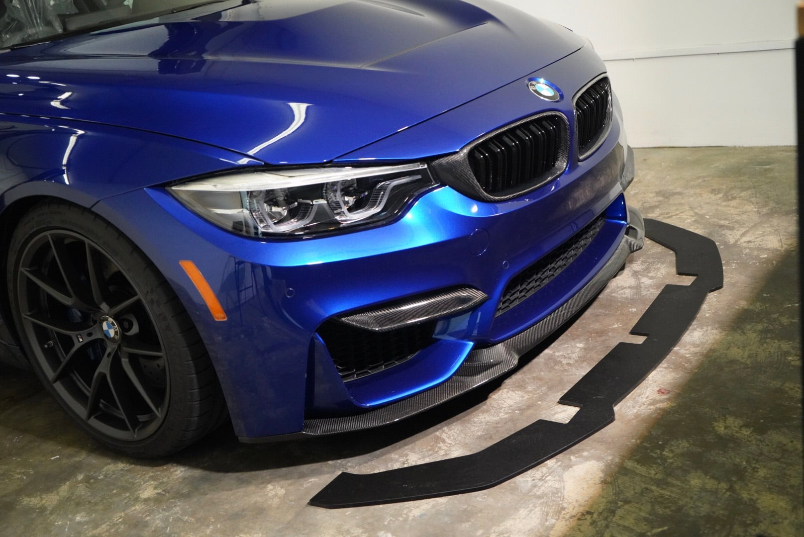 ECPR lower splitter beneath a BMW F8X CS-style carbon-fiber front lip